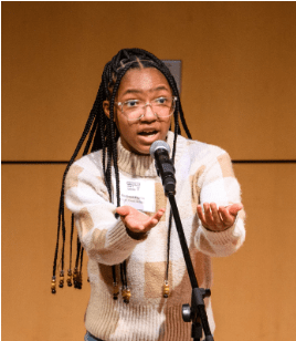 Young student reciting poetry on stage