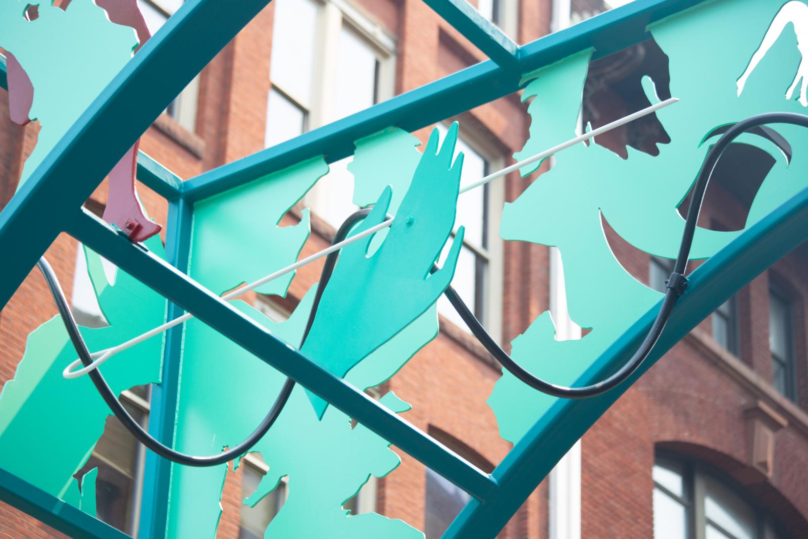 Blue-green metallic lattice with a brick building in the background